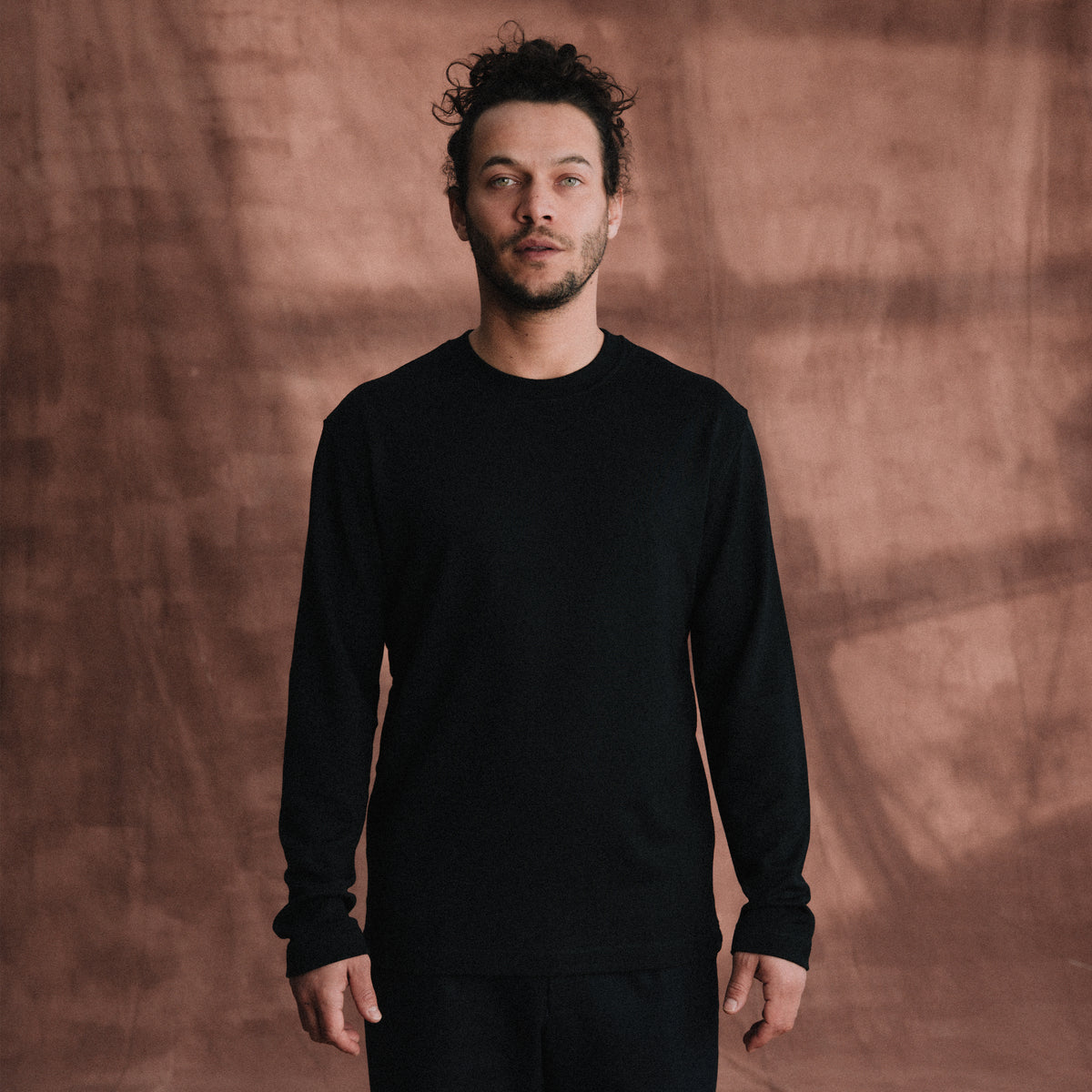 The Lightweight Sweatshirt in black heavy merino wool, model wearing front view [model: toke | size: M | length: Regular]