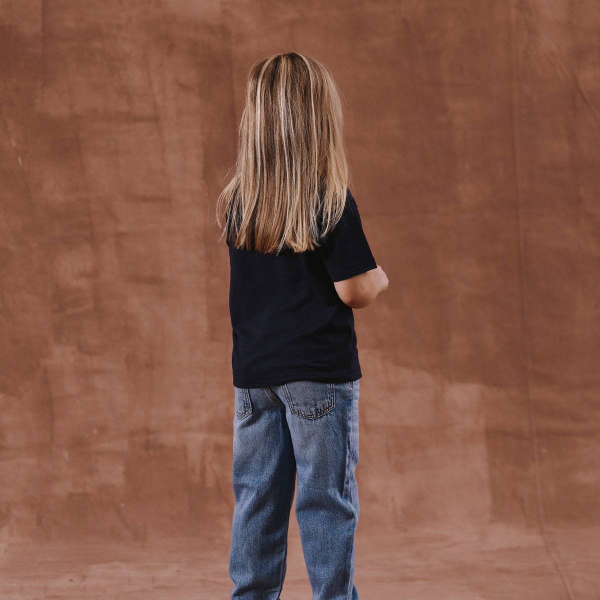 The Kids T-Shirt S/S in black soft merino wool, fabric detail [model: philine | size: 3-4 yrs]