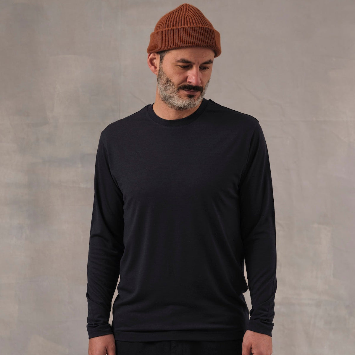 The Regular T-Shirt L/S in blue extrafine merino wool, model wearing front view [model: salih | size: M | length: Regular | note: Normally wears size L, sized down for a baselayer fit]