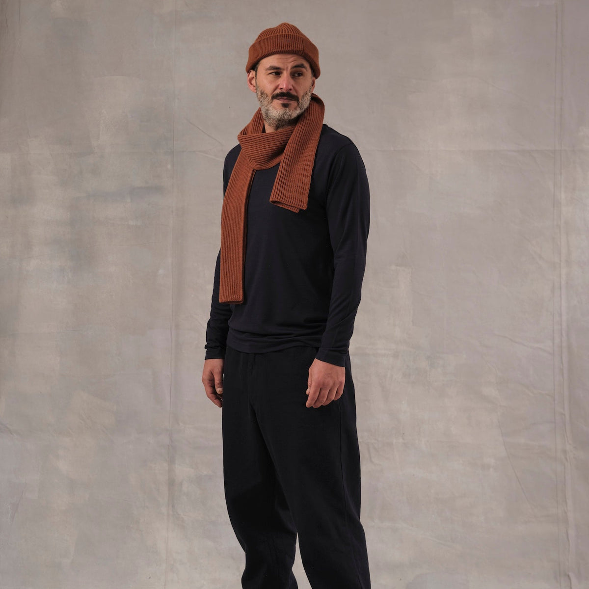 The Regular T-Shirt L/S in blue extrafine merino wool, model wearing side view [model: salih | size: M | length: Regular | note: Normally wears size L, sized down for a baselayer fit]