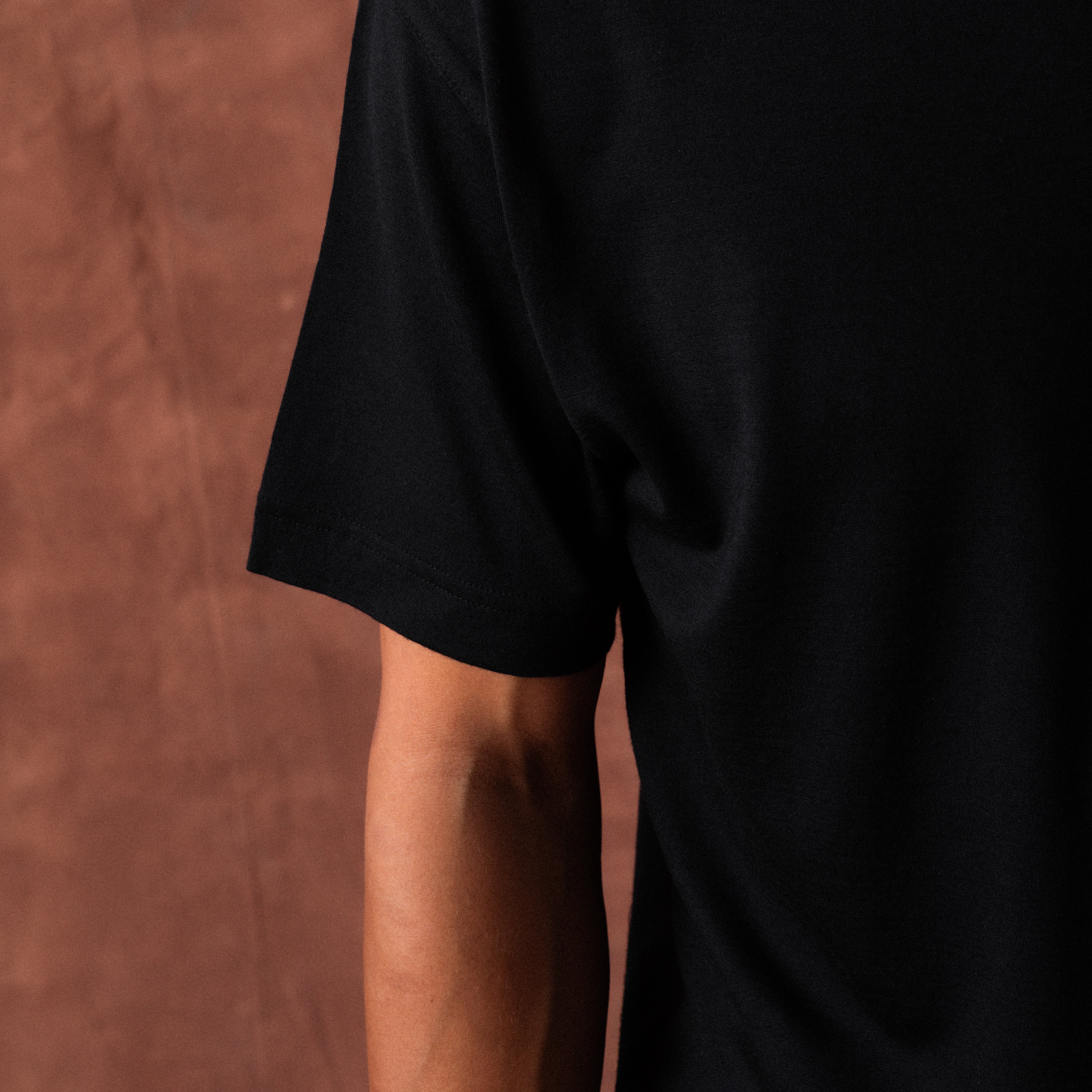 The Regular T-Shirt in black extrafine merino wool, arm view
