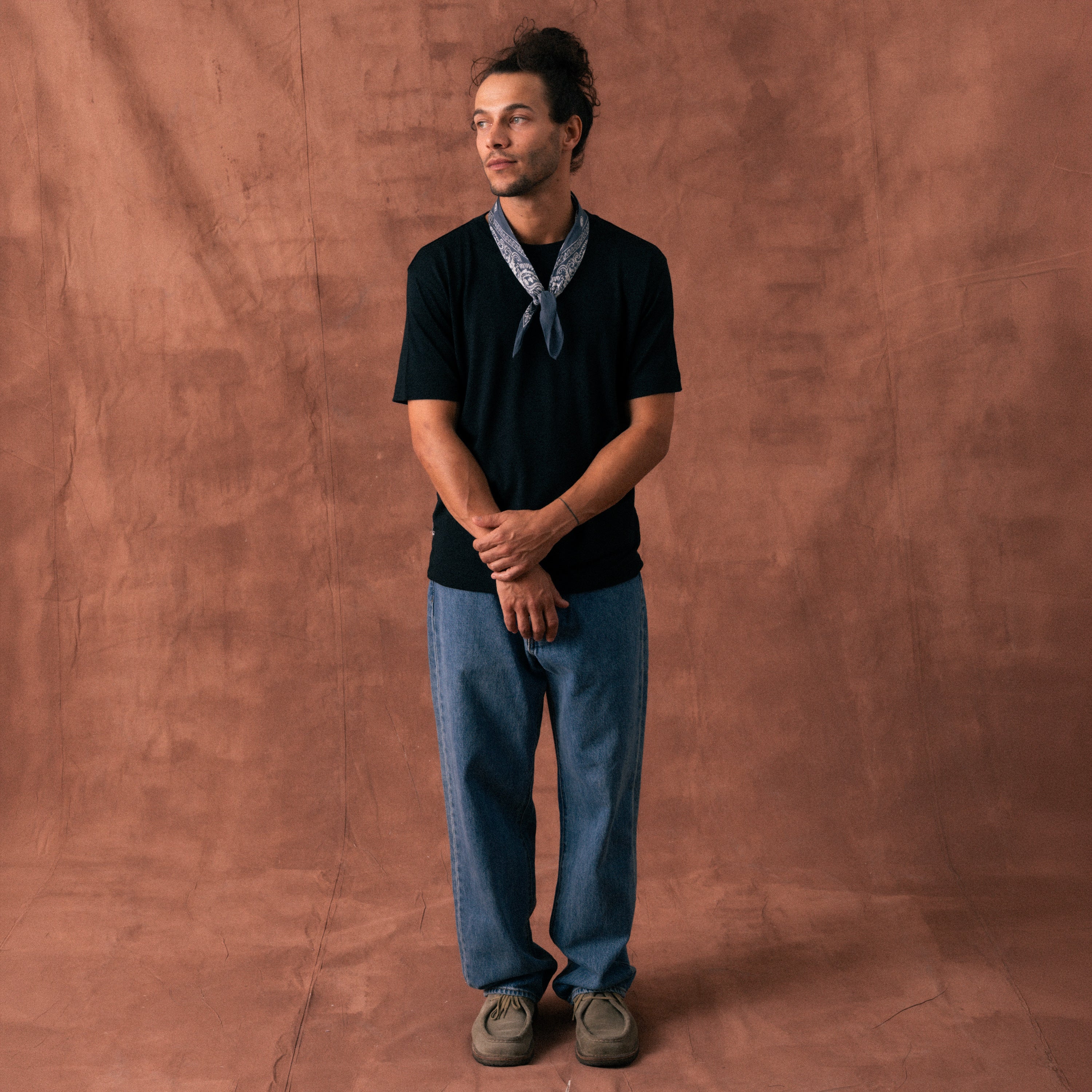 The Regular T-Shirt in black extrafine merino wool, model wearing front view
