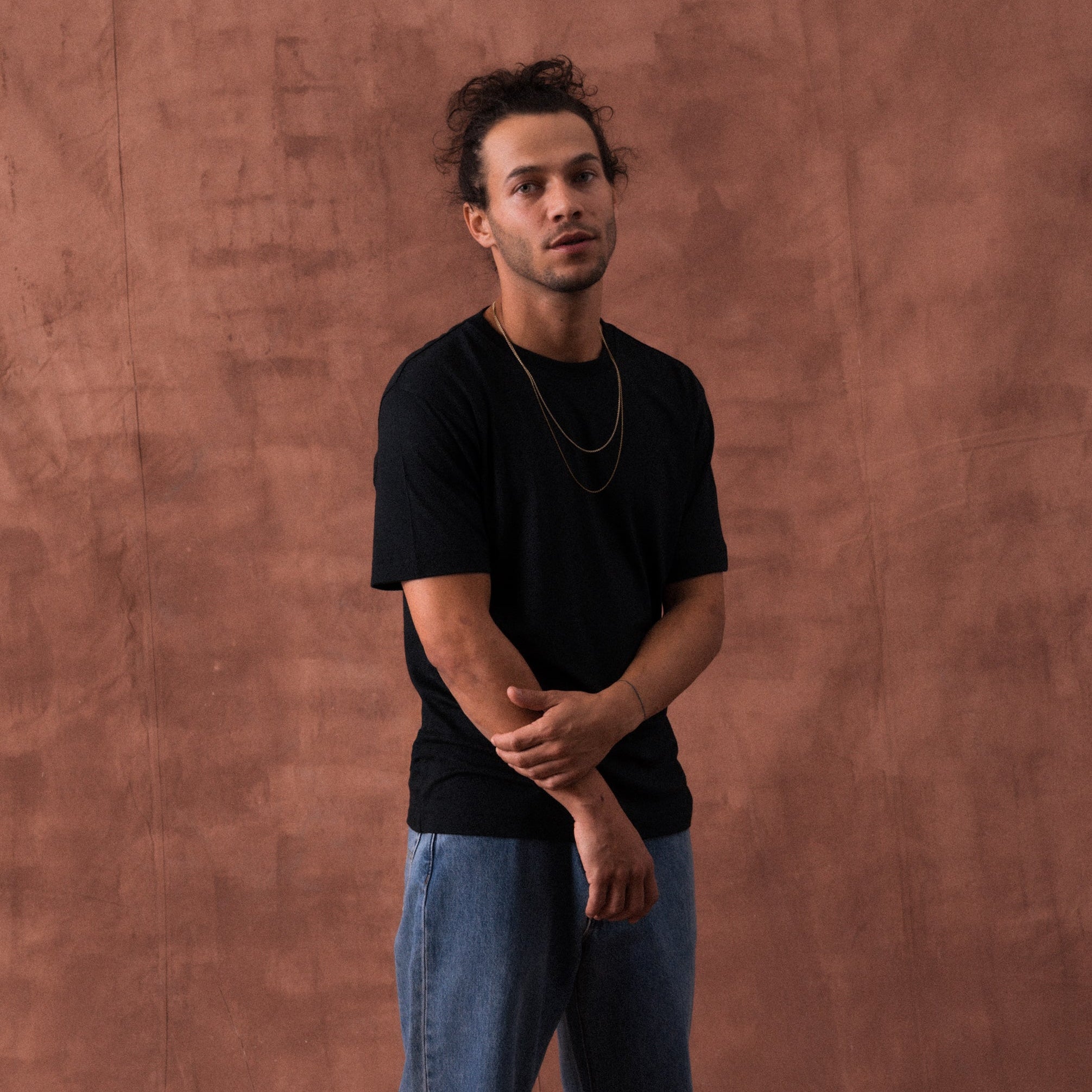 The Regular T-Shirt in black extrafine merino wool, model wearing front view
