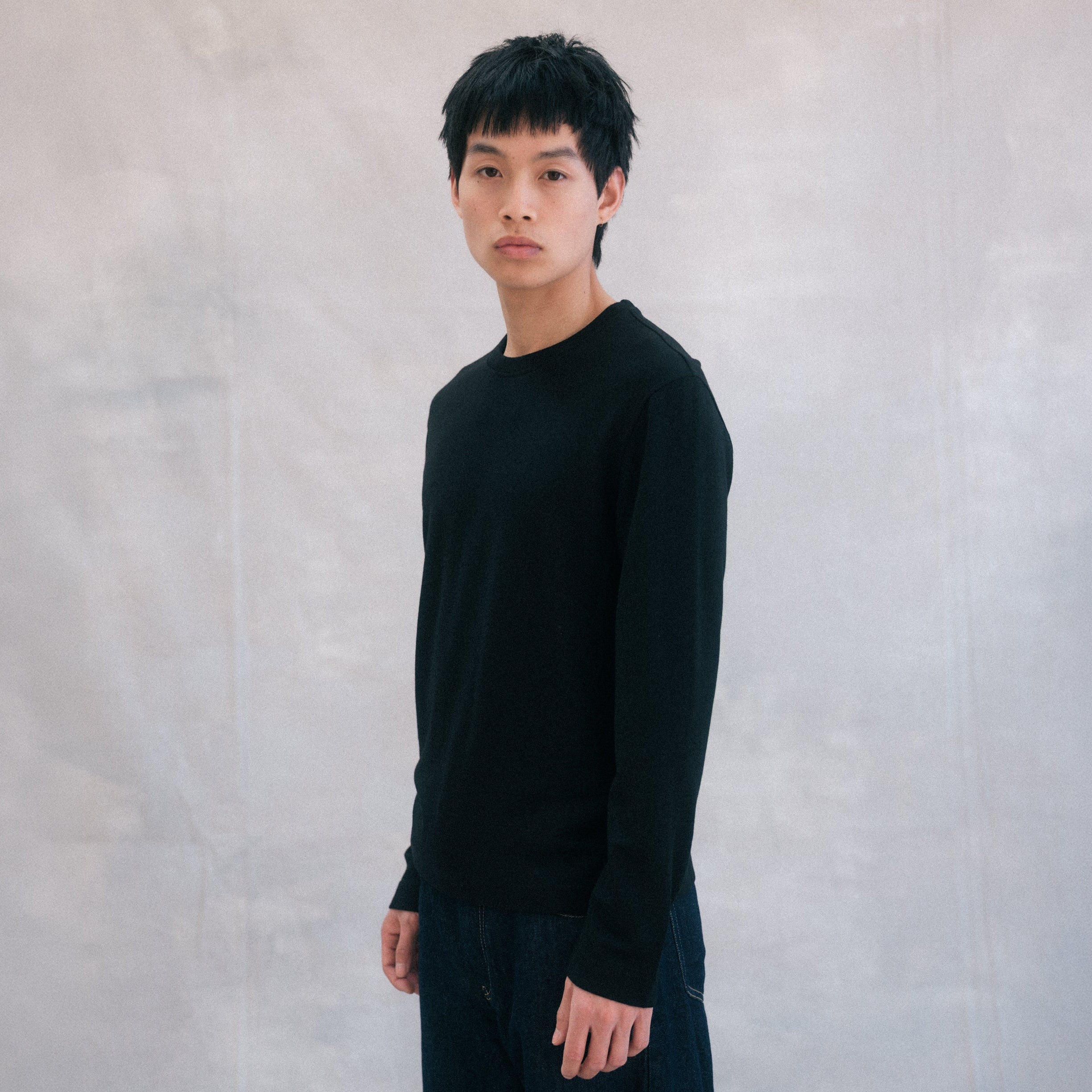 The Regular T-Shirt L/S in black extrafine merino wool, model wearing front view
